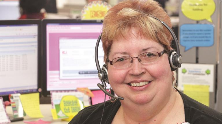 Employee with headset in front of monitors