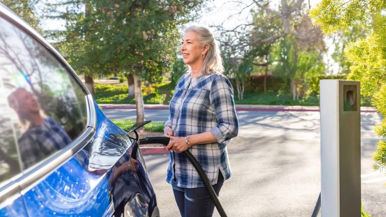 person charging electric vehicle at a charging station