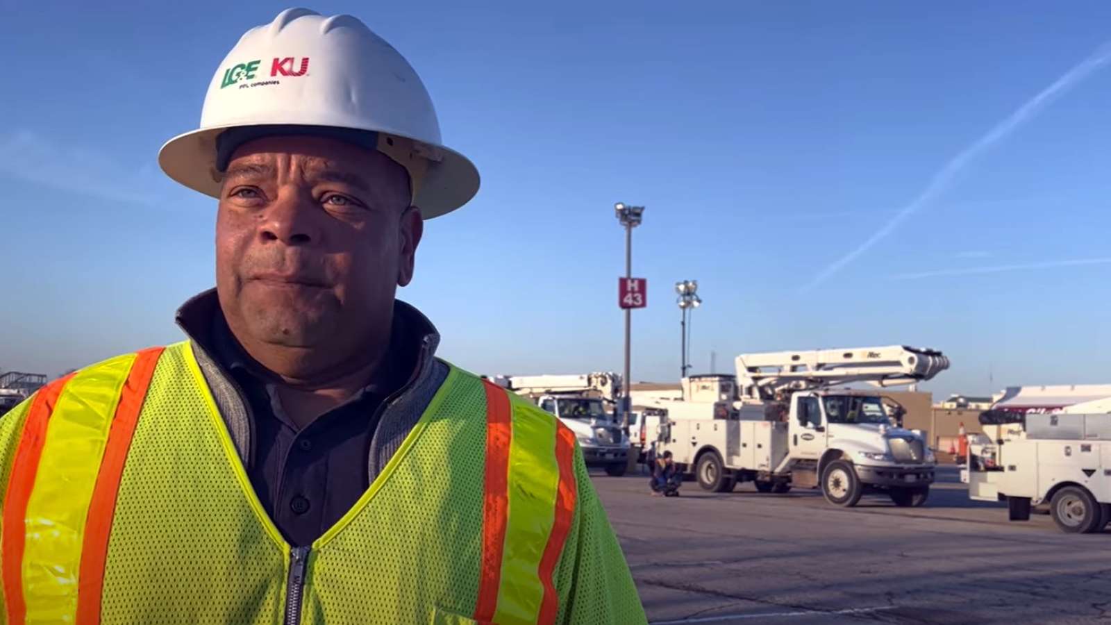 employee talking to videographer with trucks in background
