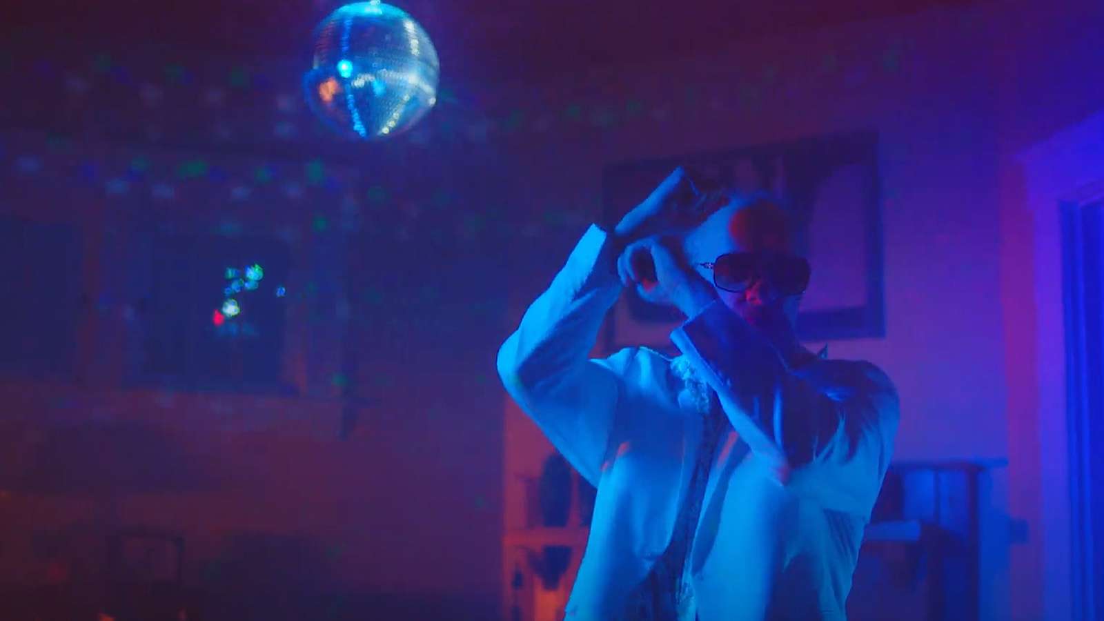 person dancing in house under a lighted mirrored disco ball