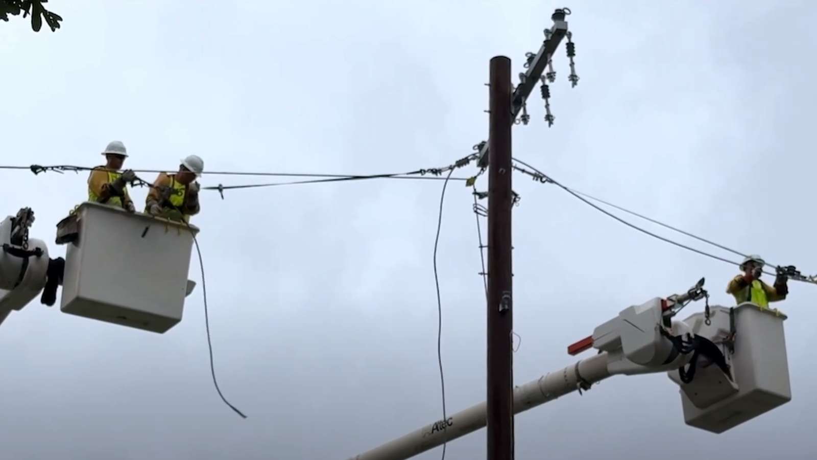 Restoration crews in bucket trucks repairing power lines