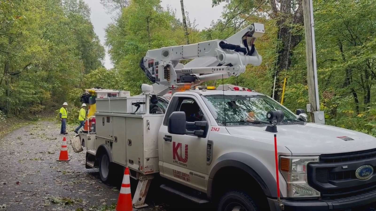 crew restoring power in a wooded area with bucket truck in foreground