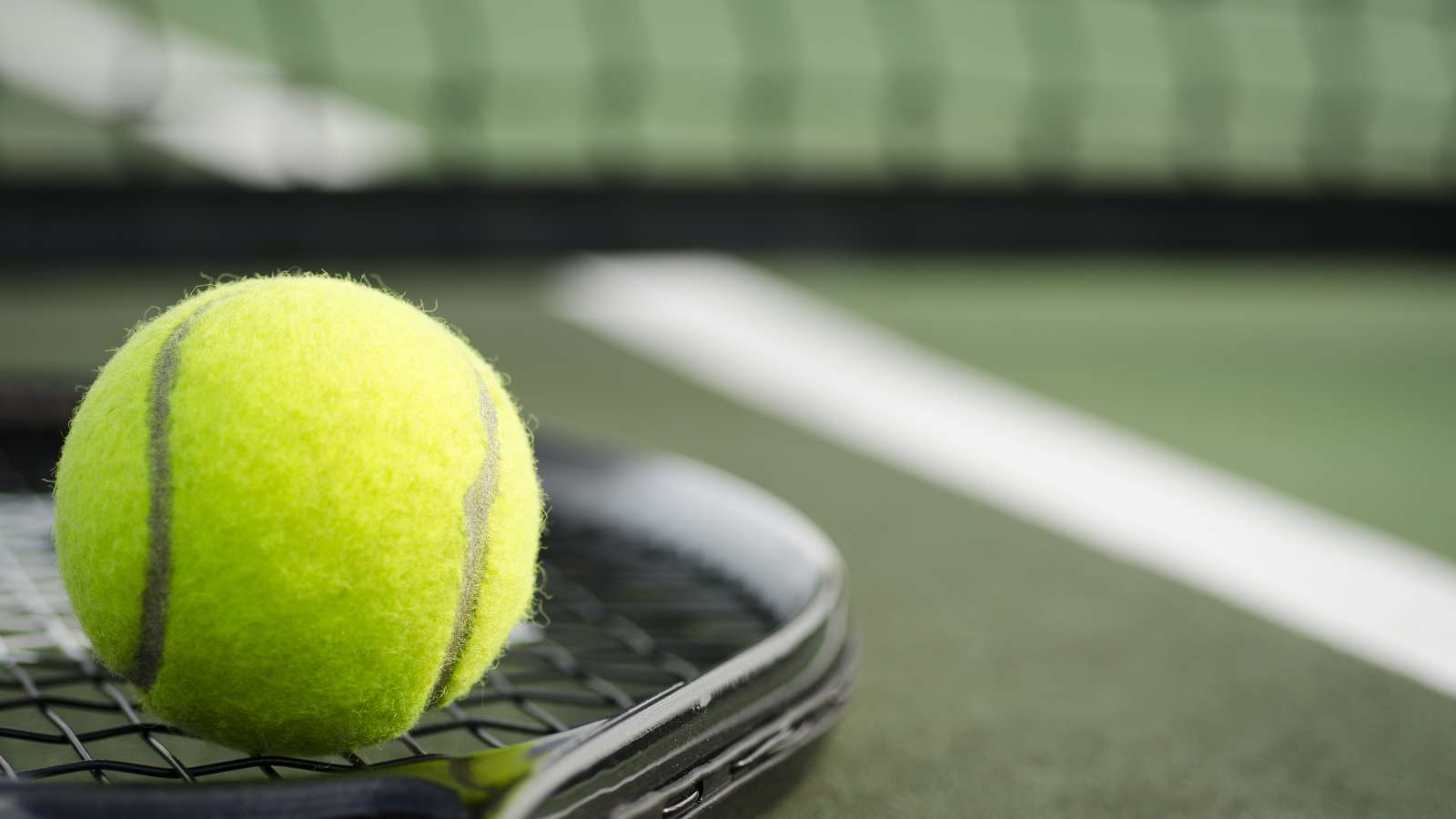 tennis ball on a racket on a tennis court
