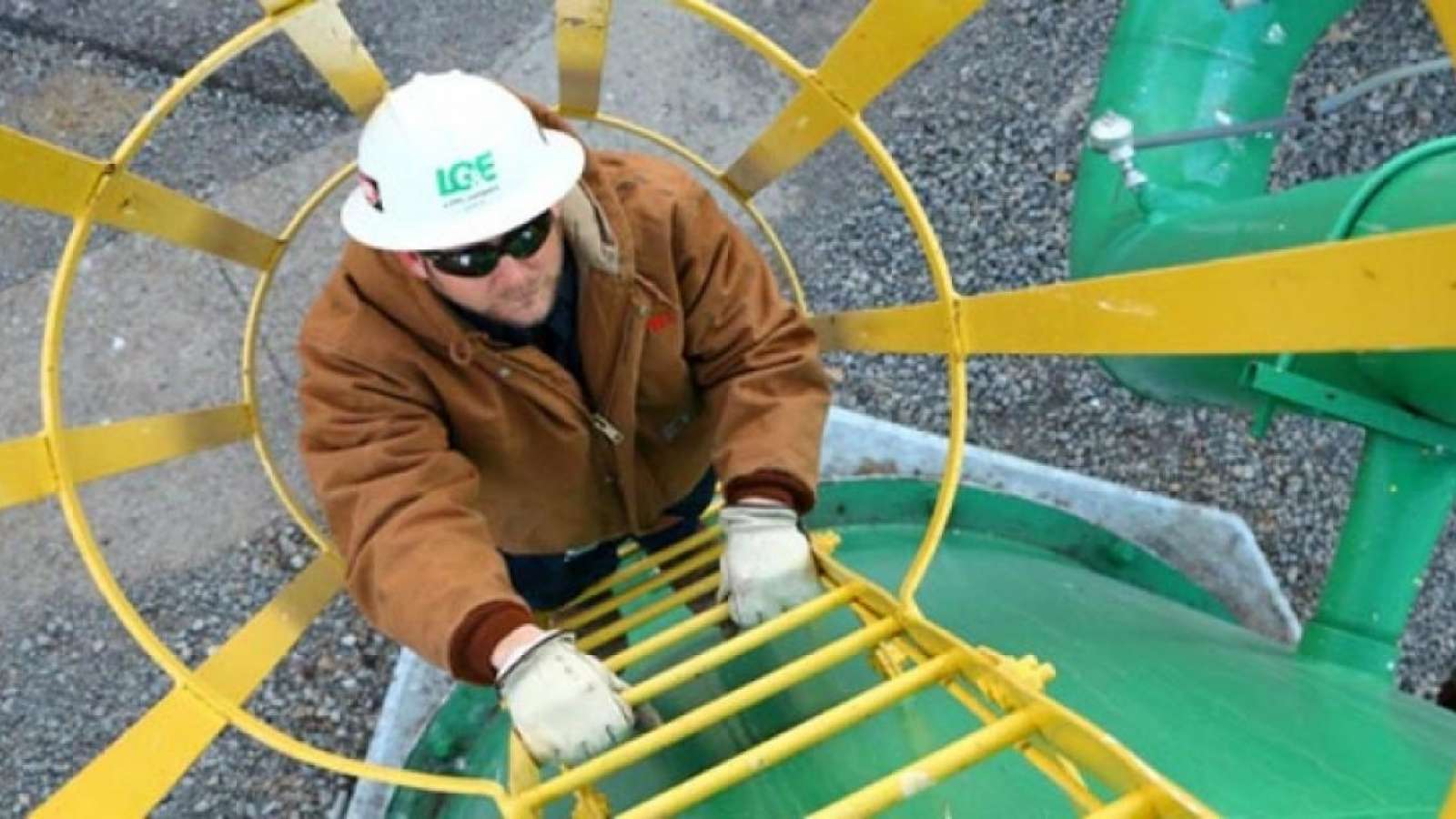 LG&E employee climbing up a safety ladder wearing hard hat