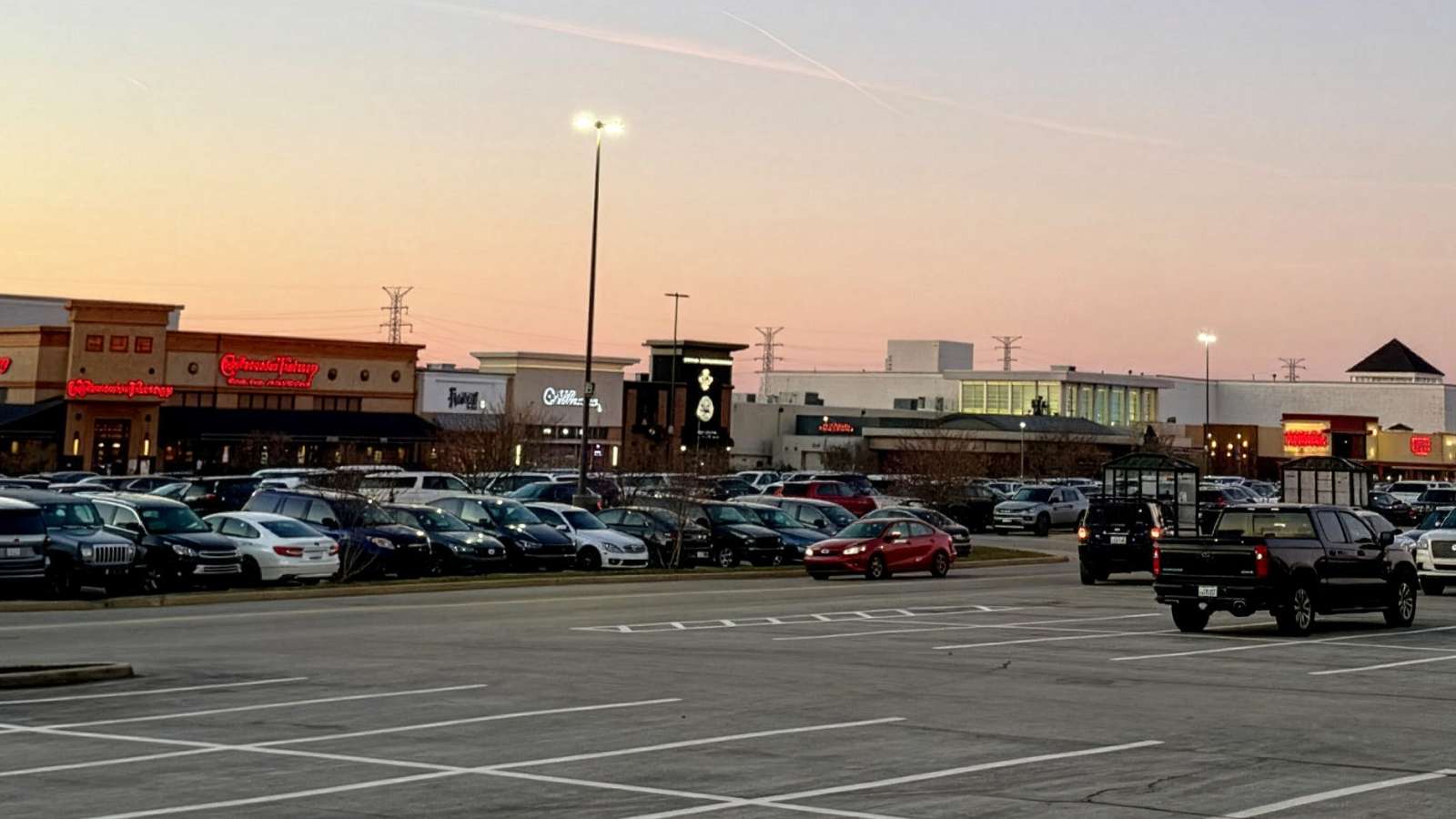view of a shopping mall from a parking lot at sunset