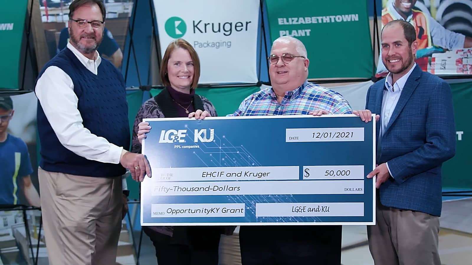 Kruger Packaging employees holding oversized check for $50,000 from LG&E and KU