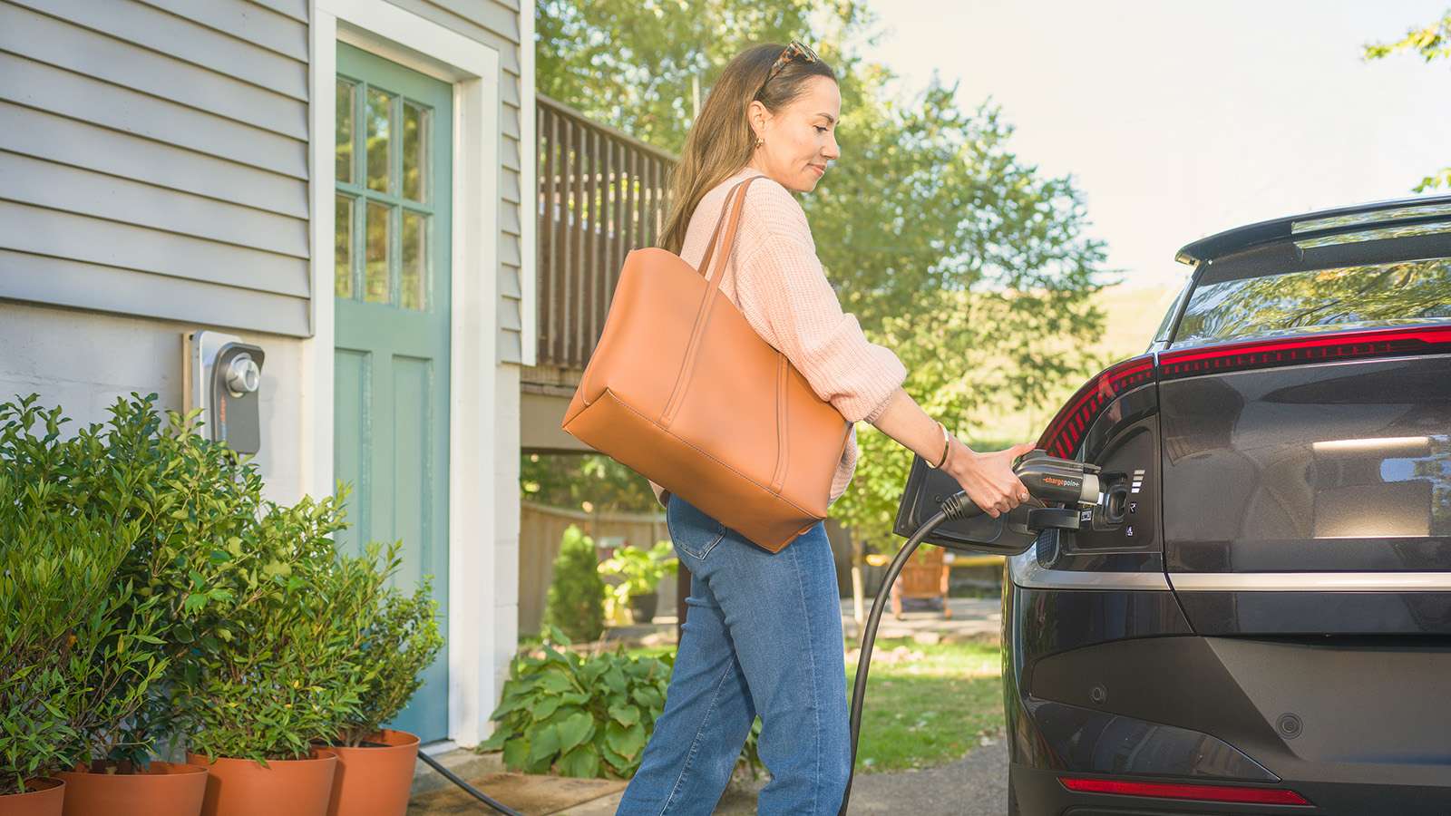 person at home connecting charger to electric vehicle