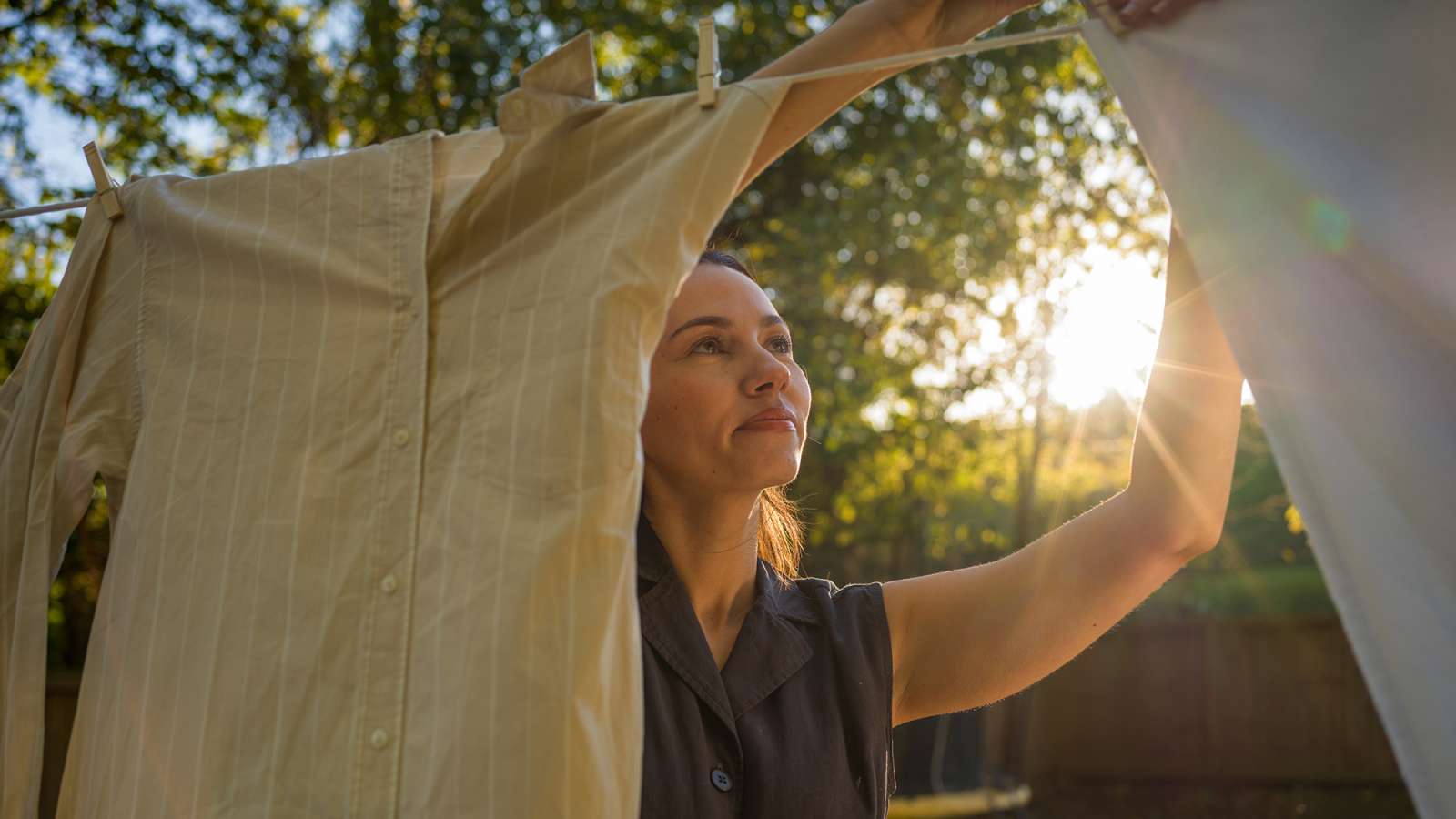 person hanging clothes on a clothesline on a sunny day