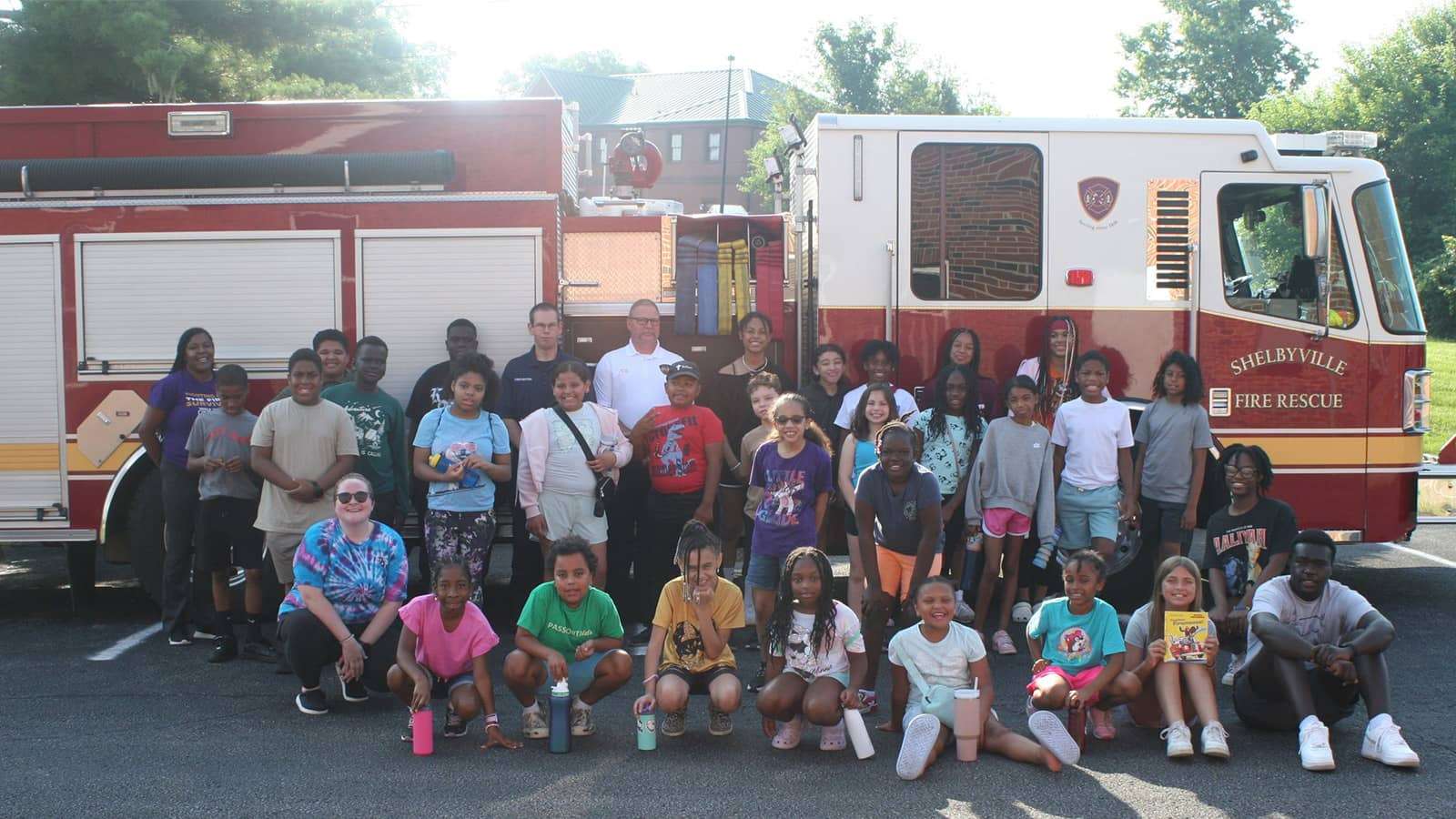 A group of volunteers in a group in front of a fire engine
