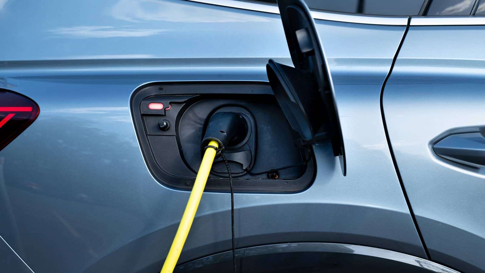 An electric vehicle with a charger connected to it.