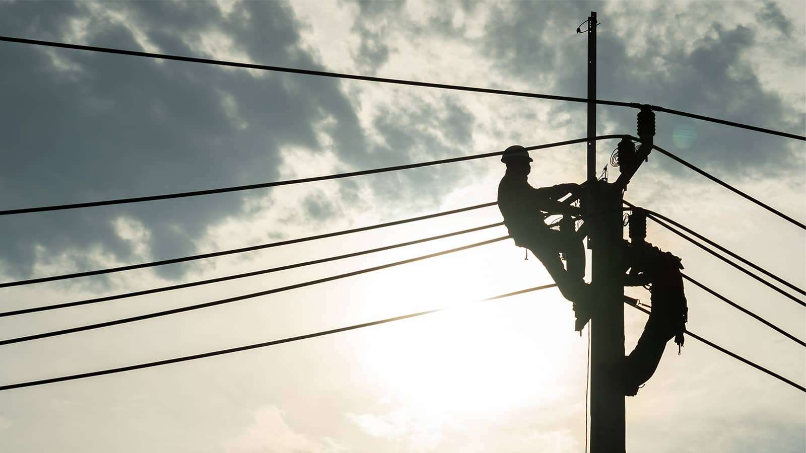 line workers on a power line pole