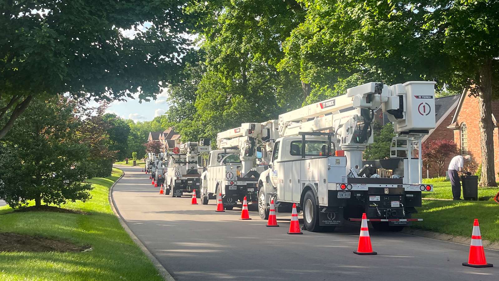 bucket trucks lined up in a neighborhood
