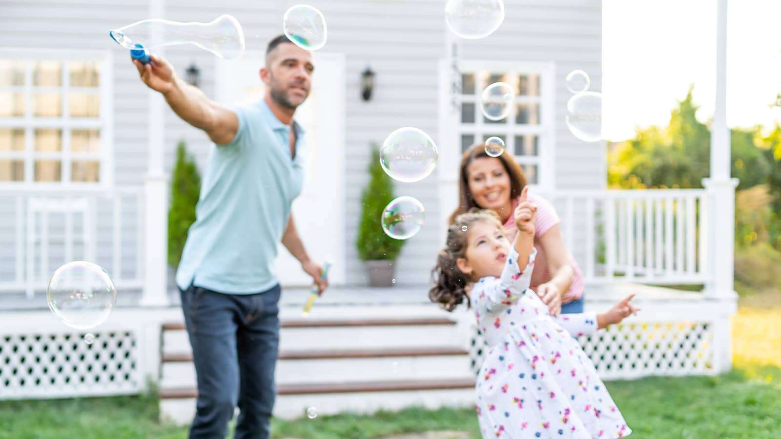 a family outside blowing bubbles