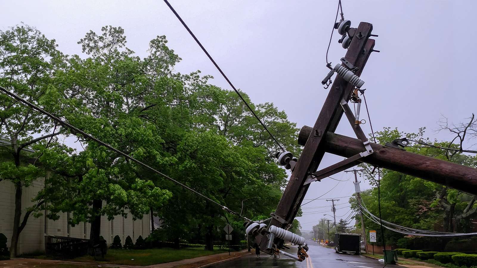 a downed power pole in a street after a storm