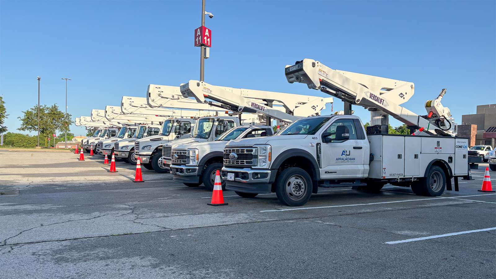 bucket trucks staging for restoration in a parking lot
