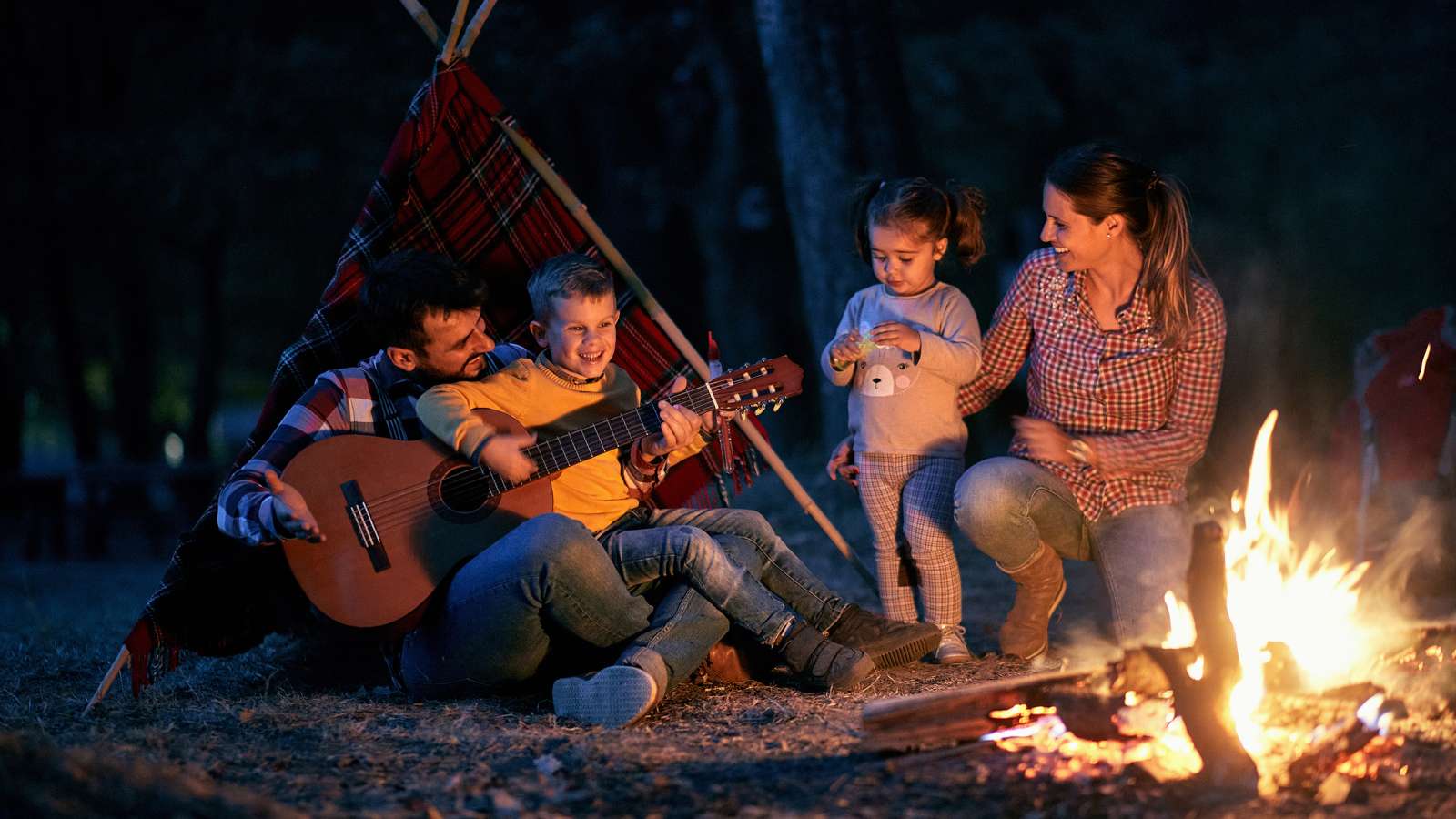 family in front of a campfire at night