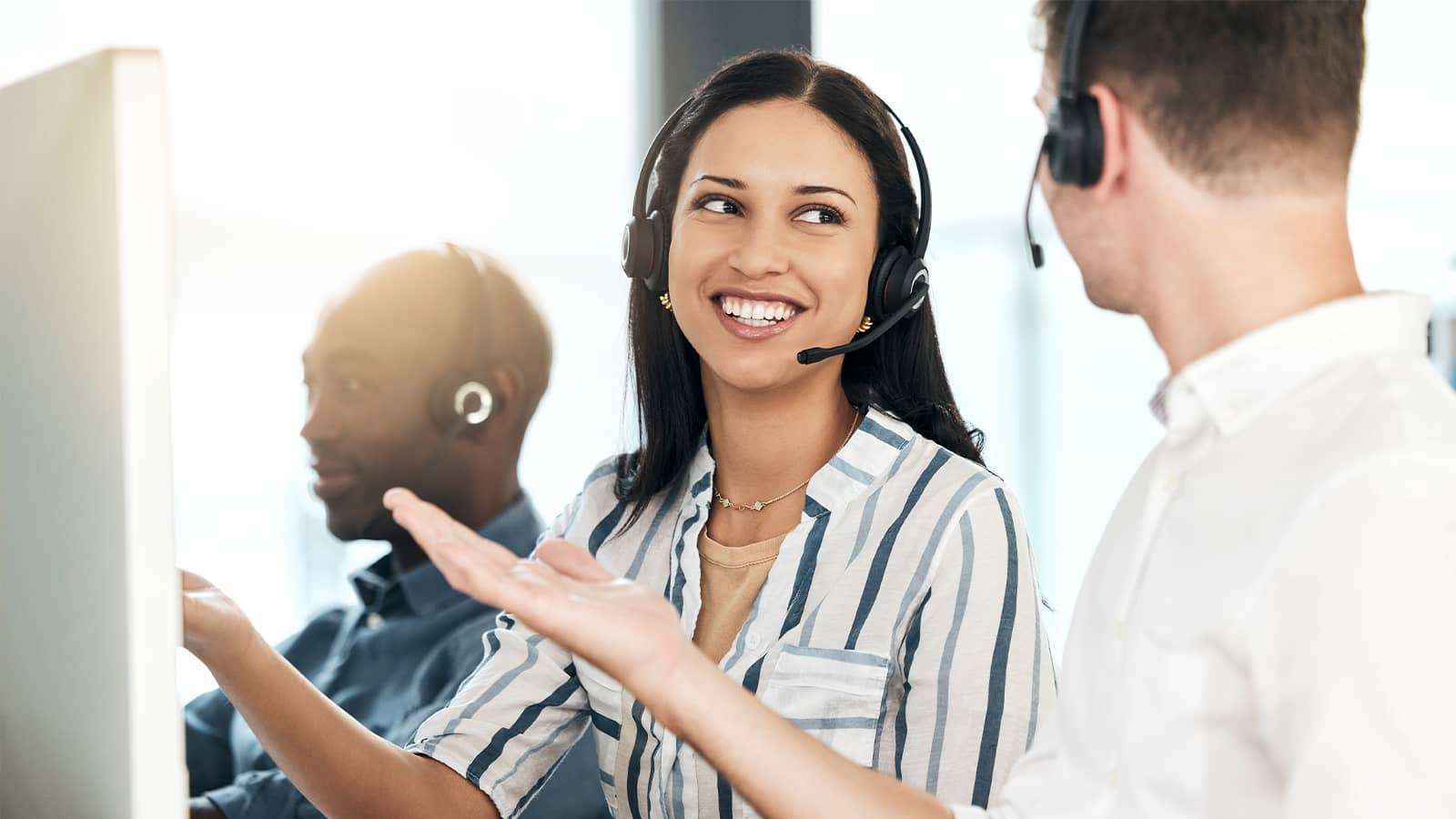 person wearing headset talking to co-workers