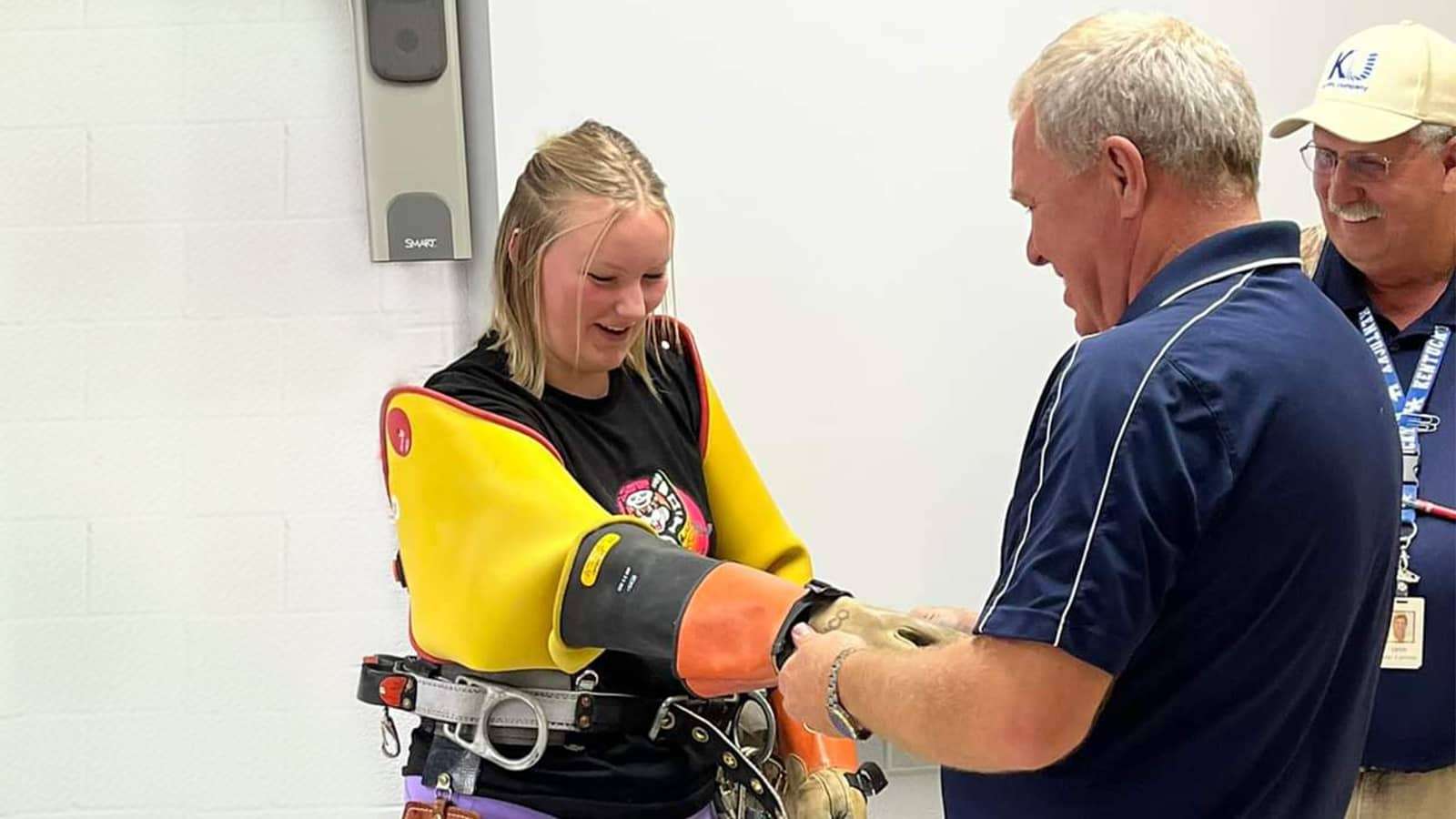 worker showing student safety equipment