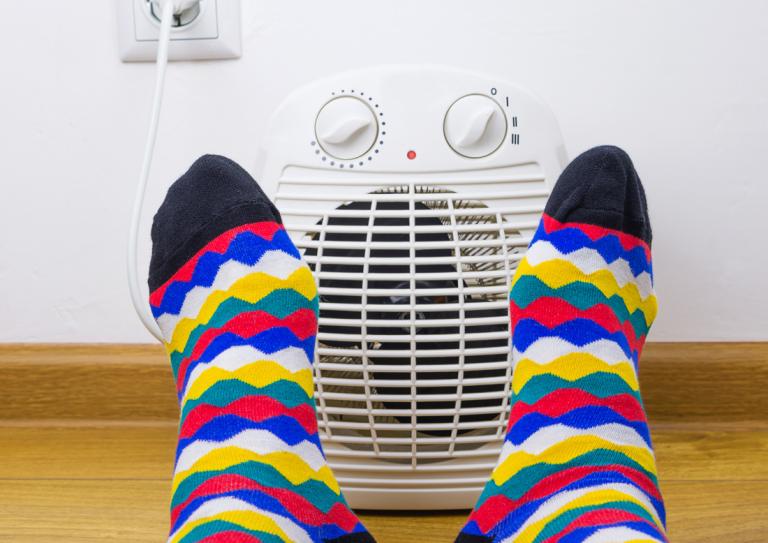 Feet with socks in front of space heater
