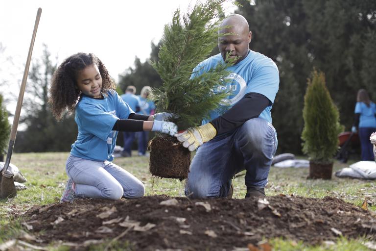 father and daughter planting a tree
