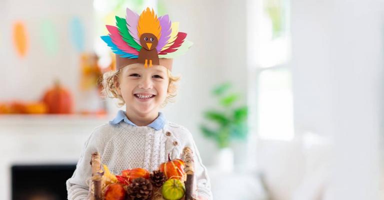 Young boy with turkey paper hat on