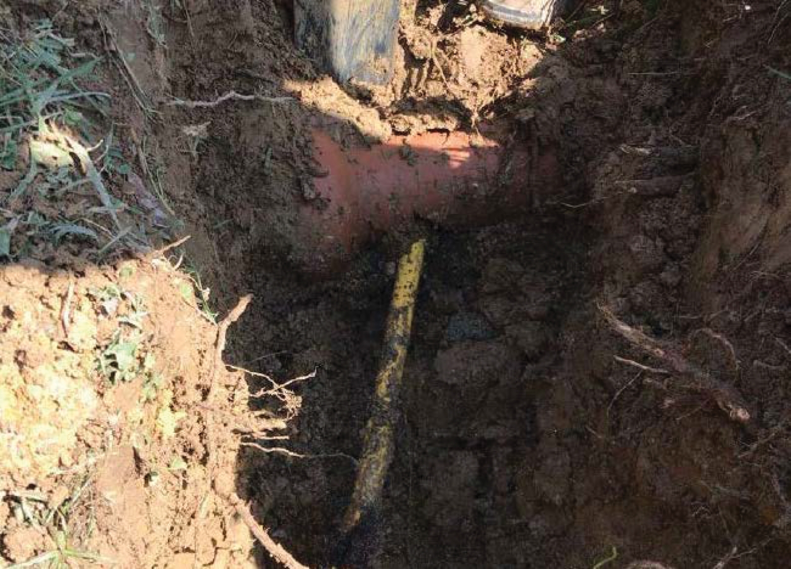 dirt trench showing a cross bore through a sewer pipe