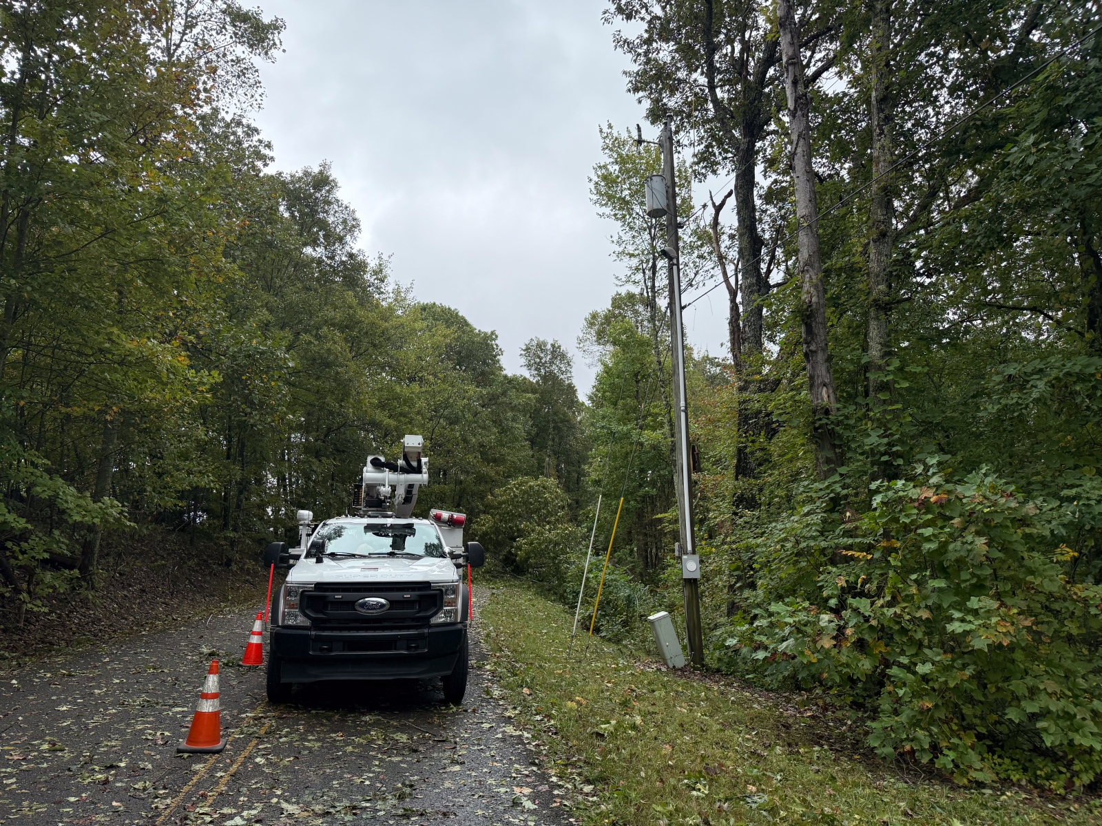 Bucket truck on road next to downed power lines