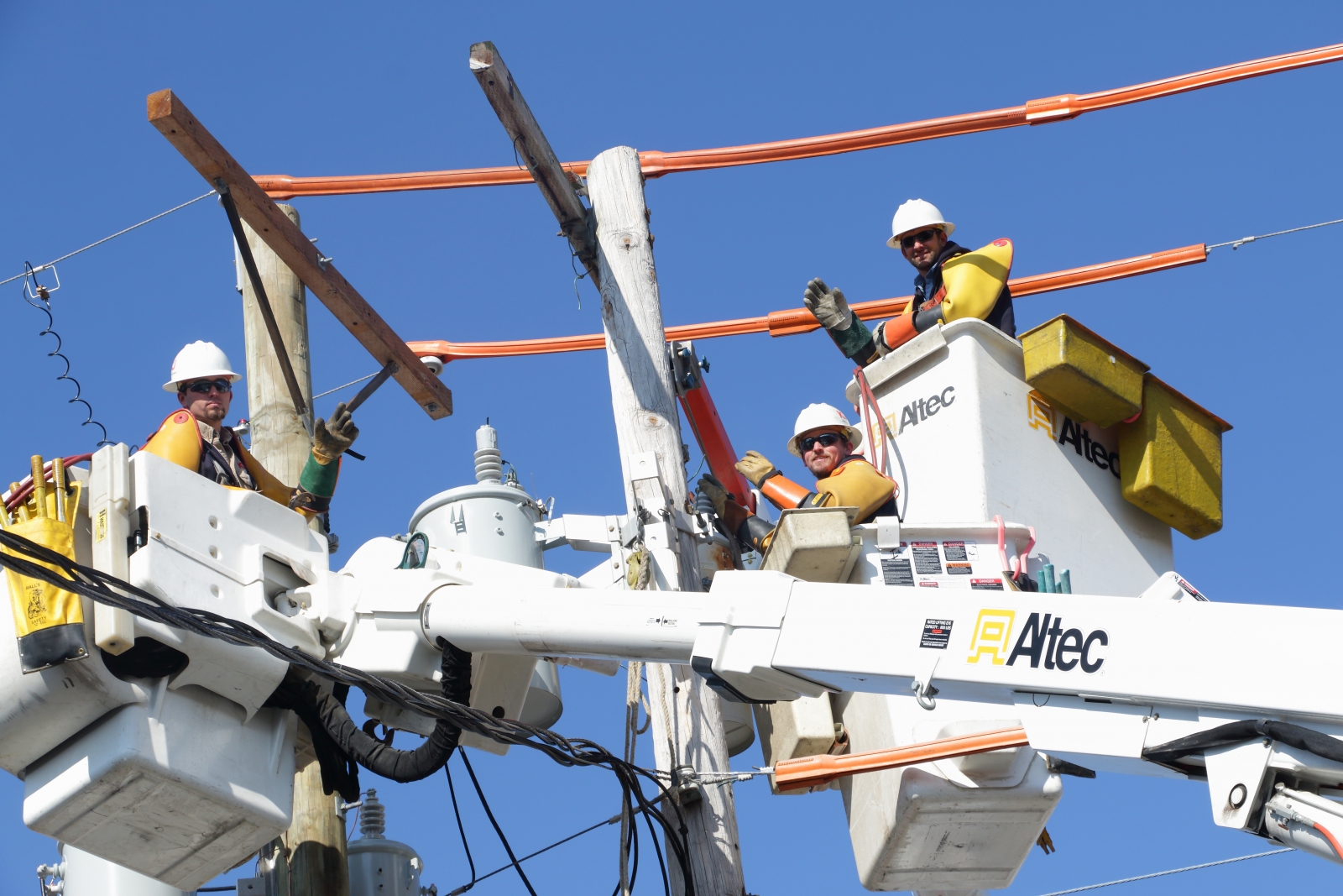 Three lineman in bucket trucks