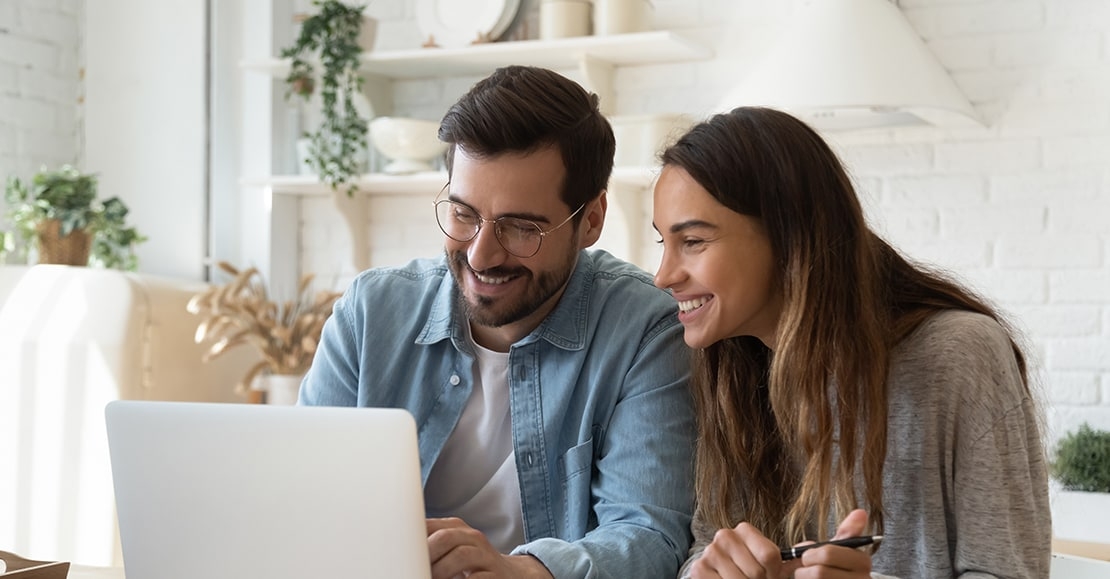 Couple looking at a laptop screen.