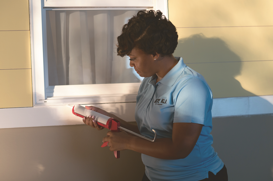 woman caulking window