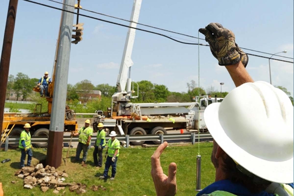 workers installing new power pole