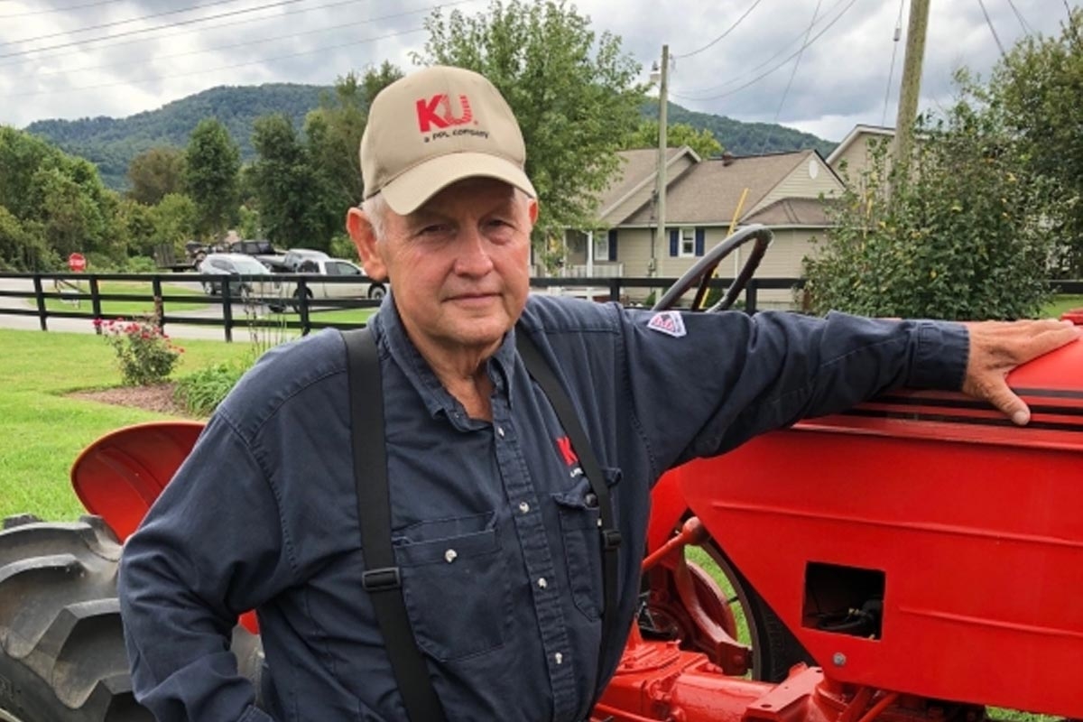 John Morrison standing in front of red tractor