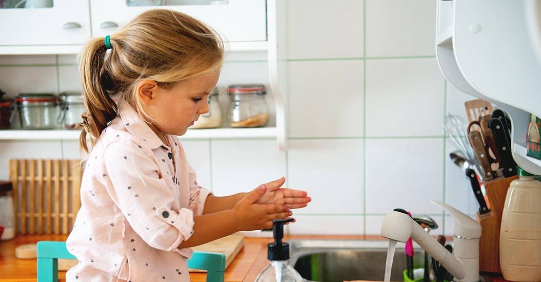 Little girl washing her hands.