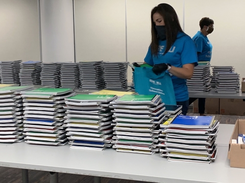 employees filling bags of school supplies