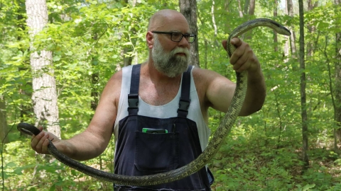 Employee Phil Peak holding a snake